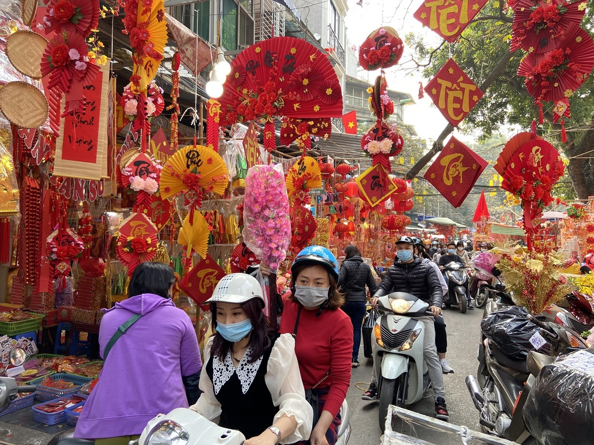 Shop owners and visitors here all wear masks to follow Covid-19 prevention measures. Visitors who want to take photos at the stalls should get permission from shop owners first. Note that you should not stand in front of the store to take photos without buying something in the morning, since many people think it would jinx business. This year's Tet market is held on streets like Hang Luoc, Hang Khoai, Hang Ruoi, Hang Ma and Phung Hung. In addition to decorative goods and silk flowers, the market sells peach blossoms, kumquat trees and some other types of fresh flowers on Phung Hung Street. (Photo: VnExpress) 4531 ct11 1612157695