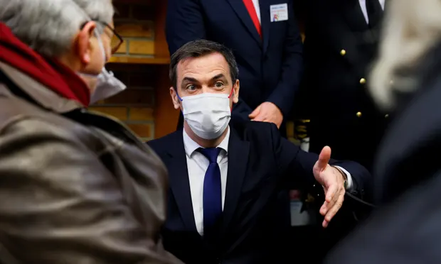 Olivier Véran, the French health minister, speaks to people waiting to receive a Covid vaccine. Véran said France should deliver 6m first jabs in March. Photograph: Thomas Samson/EPA 1231-6216