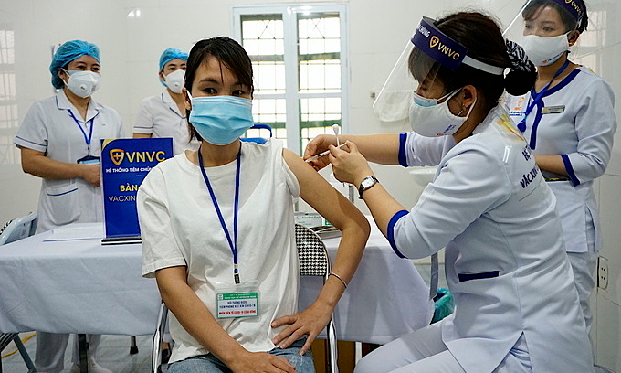 Nguyen Thi Hue, a medical worker in Hai Duong Province, is injected with AstraZeneca Covid-19 vaccine, March 8, 2021. Photo by VnExpress/Gia Chinh. 2234-tiem-1615171158-1615171551-8928-1615171569-680x408