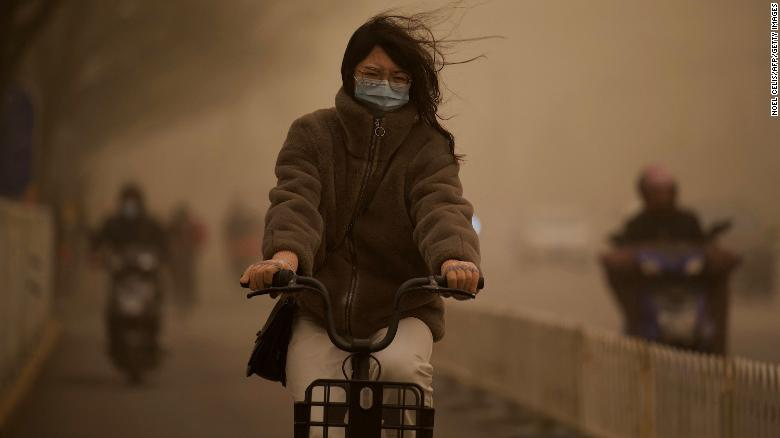 A woman cycles along a street during a sandstorm in Beijing on March 15. 5523-210315012754-01-beijing-sandstorm-0315-exlarge-169