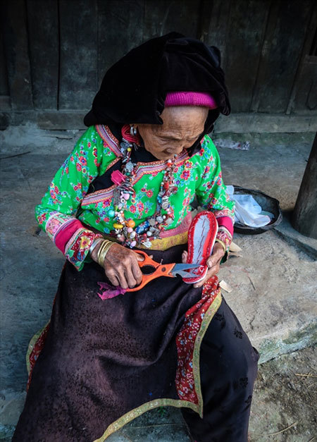 LOCAL LIVELIHOOD: An elderly Xa Phang woman making embroidered shoes outside her home. Photo laodong.vn LOCAL LIVELIHOOD: An elderly Xa Phang woman making embroidered shoes outside her home. Photo laodong.vn