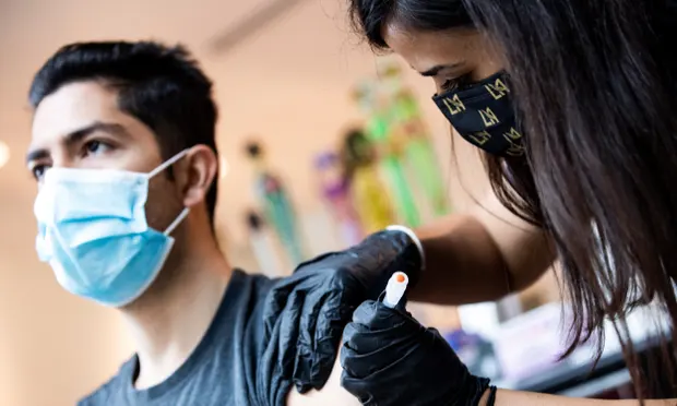 A patient is vaccinated against Covid-19 at an event organized by the Los Angeles Football Club in California. Photograph: Étienne Laurent/EPA A patient is vaccinated against Covid-19 at an event organized by the Los Angeles Football Club in California. Photograph: Étienne Laurent/EPA