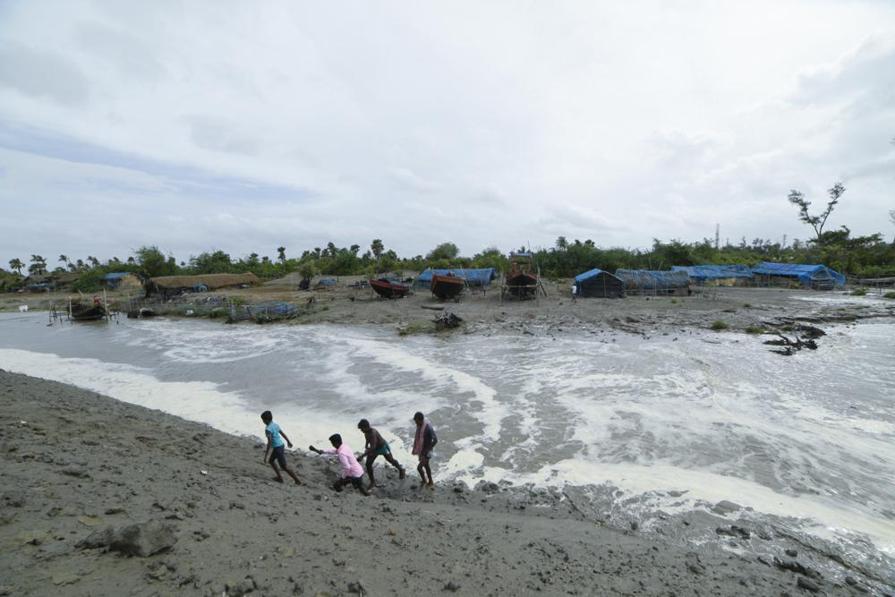 Village men walk past as sea water gushes in after breaking an embankment on the Bay of Bengal coast in South 24 parganas, West Bengal state, India, Tuesday, May 25, 2021. Tens of thousands of people are evacuating low-lying areas as Cyclone Yaas is expected to make landfall early Wednesday in Odisha and West Bengal states. (AP Photo/Mehaboob Uddin Gazi) Village men walk past as sea water gushes in after breaking an embankment on the Bay of Bengal coast in South 24 parganas, West Bengal state, India, Tuesday, May 25, 2021. Tens of thousands of people are evacuating low-lying areas as Cyclone Yaas is expected to make landfall early Wednesday in Odisha and West Bengal states. (AP Photo/Mehaboob Uddin Gazi)