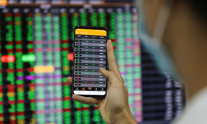 An investor looks at stock prices on a smartphone at a brokerage in HCMC's District 1, January 2020. Photo by VnExpress/Quynh Tran An investor looks at stock prices on a smartphone at a brokerage in HCMC's District 1, January 2020. Photo by VnExpress/Quynh Tran