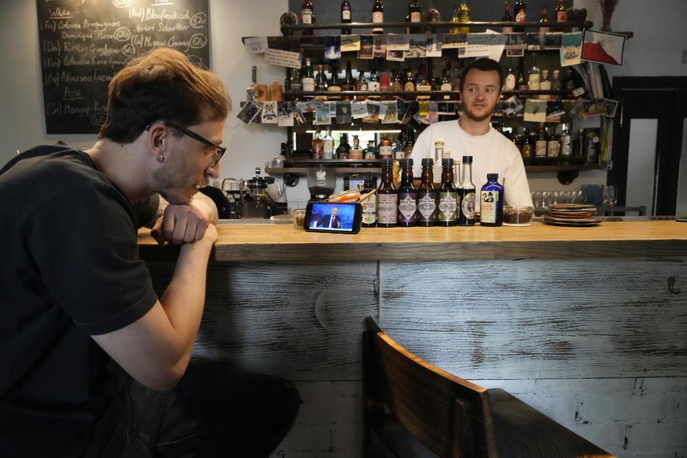 A bartender watches his smartphone showing a live stream of Russian President Vladimir Putin's annual televised call-in show, in a bar in Moscow, Russia, Wednesday, June 30, 2021. Photo: AP A bartender watches his smartphone showing a live stream of Russian President Vladimir Putin's annual televised call-in show, in a bar in Moscow, Russia, Wednesday, June 30, 2021. Photo: AP