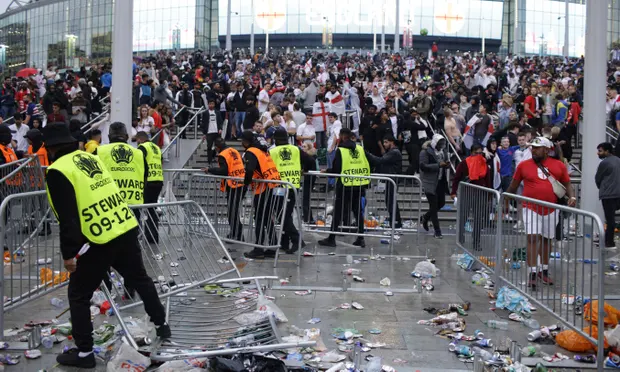 Stewards replace barricades after they were knocked over by supporters outside Wembley during the Euro 2020 final. Photograph: David Cliff/AP Stewards replace barricades after they were knocked over by supporters outside Wembley during the Euro 2020 final. Photograph: David Cliff/AP