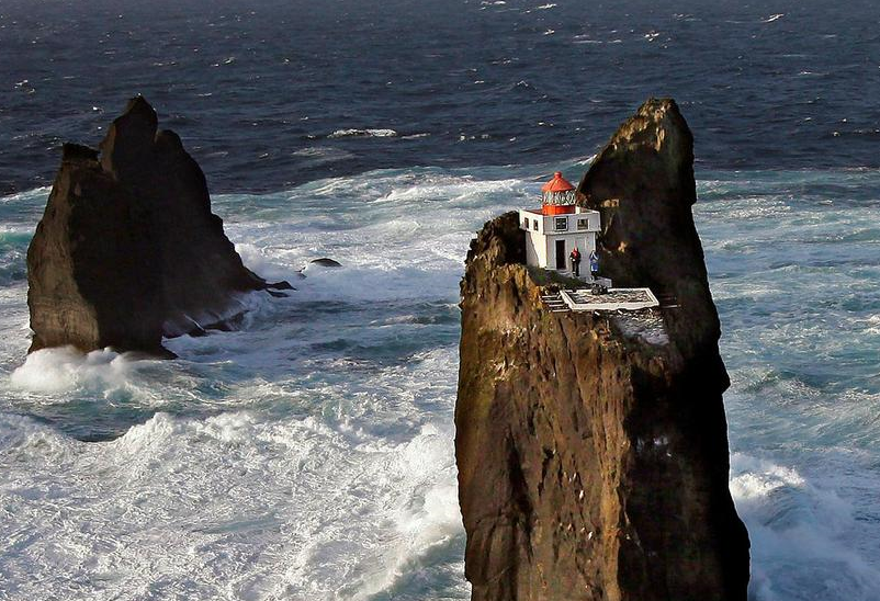 The lighthouse is surrounded by open water and is precariously perched on a cliff. Morgunblaðið/Árni Sæberg The lighthouse is surrounded by open water and is precariously perched on a cliff. Morgunblaðið/Árni Sæberg