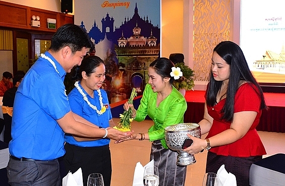 Sinh viên Lào, Campuchia thực hiện nghị thức buộc chỉ cổ tay, té nước chúc hạnh phúc, thành công và nhiều may mắn nhân dịp Tết cổ truyền của hai nước. 