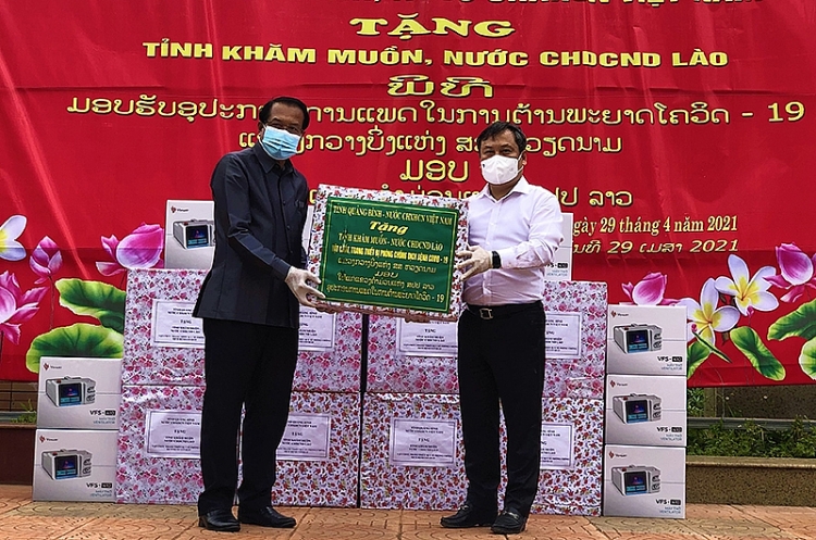 Bí thư Tỉnh ủy Quảng Bình Vũ Đại Thắng (áo trắng) trao tặng thiết bị phòng chống dịch cho lãnh đạo tỉnh Khăm Muộn.