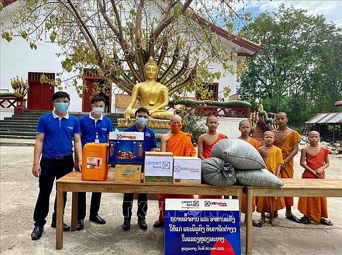 Ngân hàng Lào Việt chi nhánh Luang Prabang trao quà cho các chư tăng để hỗ trợ phòng chống dịch bệnh COVID-19. (Ảnh: TTXVN) Ngân hàng Lào Việt chi nhánh Luang Prabang trao quà cho các chư tăng để hỗ trợ phòng chống dịch bệnh COVID-19. (Ảnh: TTXVN)