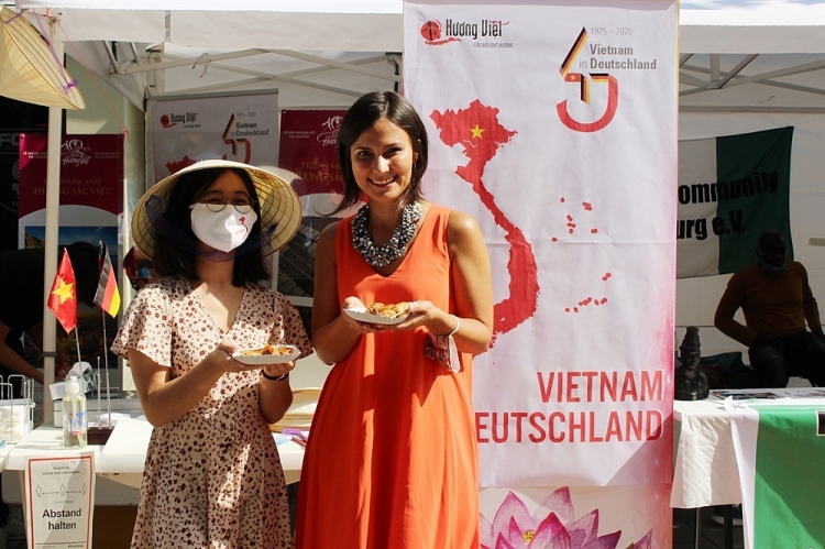 Phó Thị trưởng thành phố Augsburg, bà Martina Wild (áo dài cam), ấn tượng với ẩm thực và nón lá của Việt Nam. (Nguồn: TTXVN) 2315 14092020090627320vna potal du lich viet nam quang ba hinh anh viet nam tai mien nam nuoc duc 5015462
