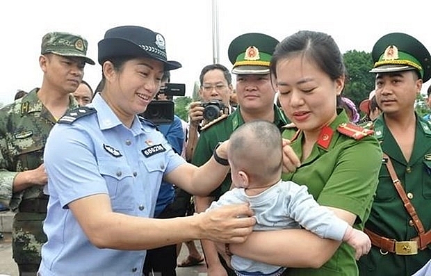Lực lượng chức năng Việt Nam tiếp nhận em bé bị bán sang Trung Quốc. (Nguồn: TTXVN) Lực lượng chức năng Việt Nam tiếp nhận em bé bị bán sang Trung Quốc. (Nguồn: TTXVN)