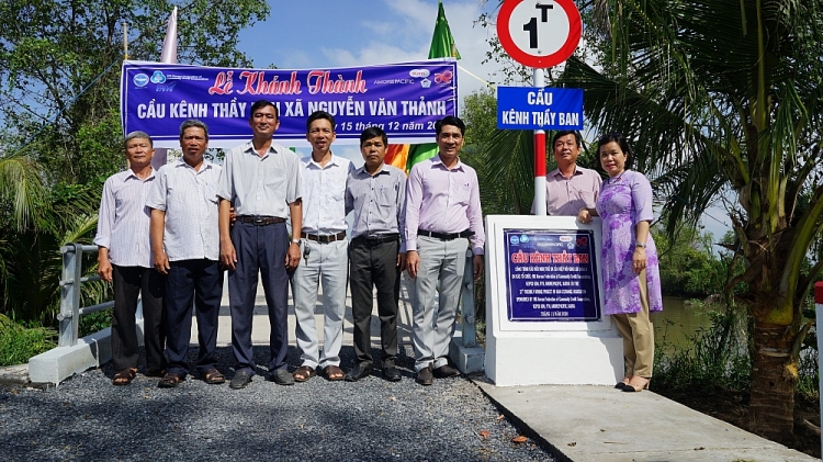 Các đại biểu và đại diện nhà tài trợ chụp hình lưu niệm trên cầu vừa khánh thành.