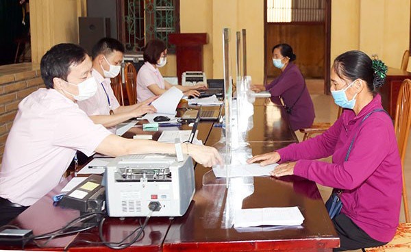 Người dân làm thủ tục vay vốn tại điểm giao dịch của Ngân hàng Chính sách xã hội ở xã Phù Linh (huyện Sóc Sơn). Ảnh: Hà Nội mới Người dân làm thủ tục vay vốn tại điểm giao dịch của Ngân hàng Chính sách xã hội ở xã Phù Linh (huyện Sóc Sơn). Ảnh: Hà Nội mới