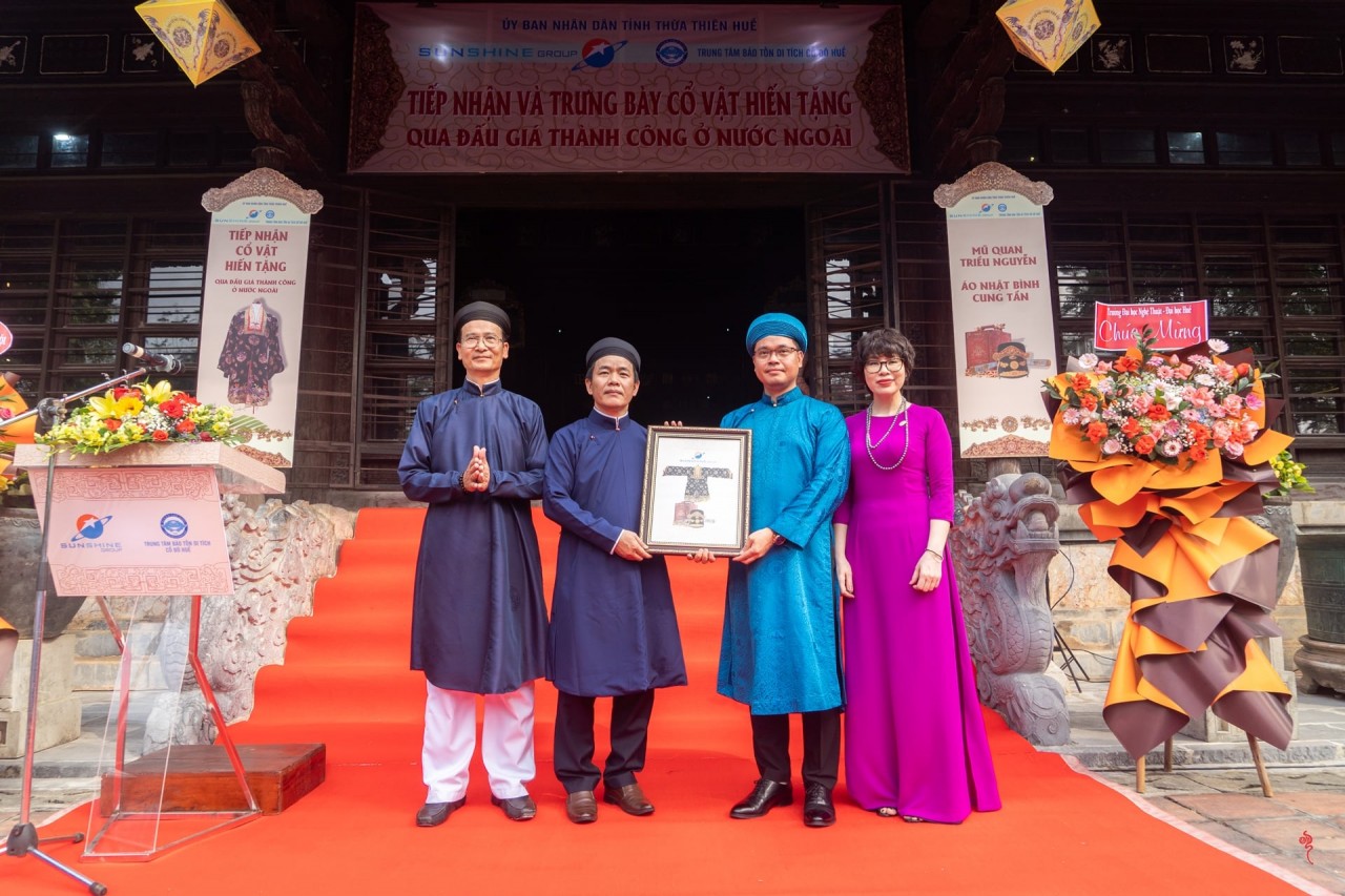 Lãnh đạo tỉnh Thừa Thiên Huế tiếp nhận hai cổ vật gồm mũ quan đại thần và áo Nhật Bình cung tần triều Nguyễn do doanh nghiệp hiến tặng. Ảnh: Trung tâm Bảo tồn Di tích Cố đô Huế 