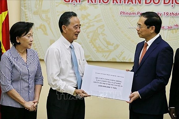 President of the Khmer-Vietnam Association in Cambodia Sim Chy, on behalf of the Vietnamese expats there, receives pre-Tet gifts from Minister of Foreign Affairs Bui Thanh Son. (Photo: VNA) President of the Khmer-Vietnam Association in Cambodia Sim Chy, on behalf of the Vietnamese expats there, receives pre-Tet gifts from Minister of Foreign Affairs Bui Thanh Son. (Photo: VNA)