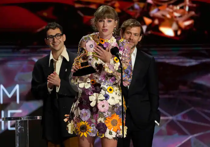 Taylor Swift accepts the award for album of the year for “Folklore” at the 63rd annual Grammy Awards in Los Angeles. In the background are her collaborators, Jack Antonoff, left, and Aaron Dessner. (Chris Pizzello/Invision/AP) Taylor Swift accepts the award for album of the year for “Folklore” at the 63rd annual Grammy Awards in Los Angeles. In the background are her collaborators, Jack Antonoff, left, and Aaron Dessner. (Chris Pizzello/Invision/AP)