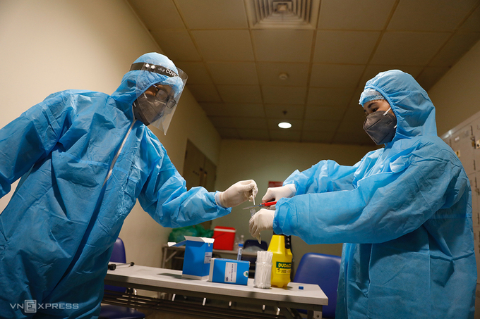 Medical workers collect samples for Covid-19 testing at Tan Son Nhat International Airport in Ho Chi Minh City. Photo: VnExpress Medical workers collect samples for Covid-19 testing at Tan Son Nhat International Airport in Ho Chi Minh City. Photo: VnExpress