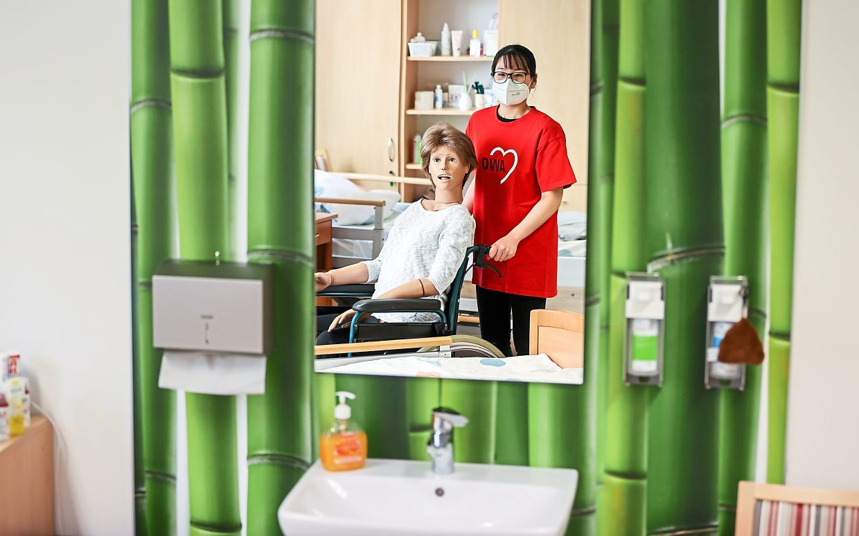 Phung uses training dummy Elvira at the Arbeiterwohlfahrt Vogtland (AWO). She and two other young women came to Vogtland from Vietnam in 2017 and work as skilled nursing staff. Photos: Jan Woitas/dpa-Zentralbild/dpa Phung uses training dummy Elvira at the Arbeiterwohlfahrt Vogtland (AWO). She and two other young women came to Vogtland from Vietnam in 2017 and work as skilled nursing staff. Photos: Jan Woitas/dpa-Zentralbild/dpa