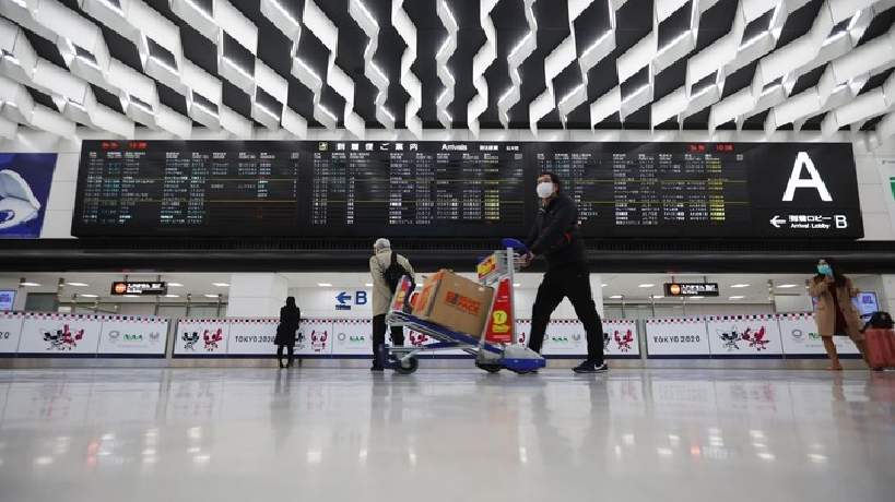 People walk through the Narita Airport with masks following an outbreak of the new coronavirus in Japan, March 9, 2020. Photo by Reuters. 5228 japan 2