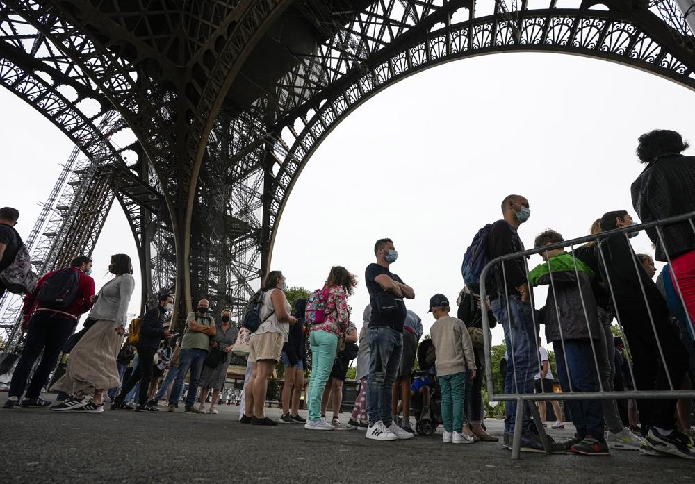Visitor line up at the Eiffel Tower in Paris, Friday, July 16, 2021. The Eiffel Tower is reopening Friday for the first time in nine months, just as France faces new virus rules aimed at taming the fast-spreading delta variant. The Eiffel Tower Reopens After Nine-Month Closure, With Covid Passes Required