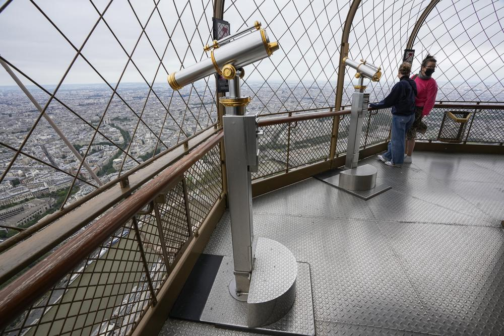 Visitors enjoy the view from top of the Eiffel Tower in Paris, Friday, July 16, 2021. The Eiffel Tower is reopening Friday for the first time in nine months, just as France faces new virus rules aimed at taming the fast-spreading delta variant. The Eiffel Tower Reopens After Nine-Month Closure, With Covid Passes Required