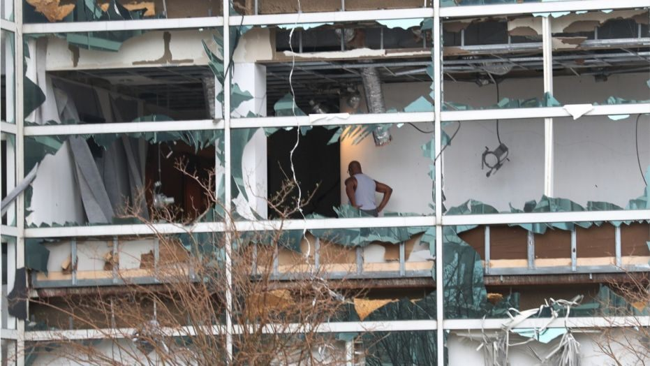 A person is seen through the blown out windows of the Capitol One Bank Tower in the downtown area of Lake Charles on Thursday. 1122 building