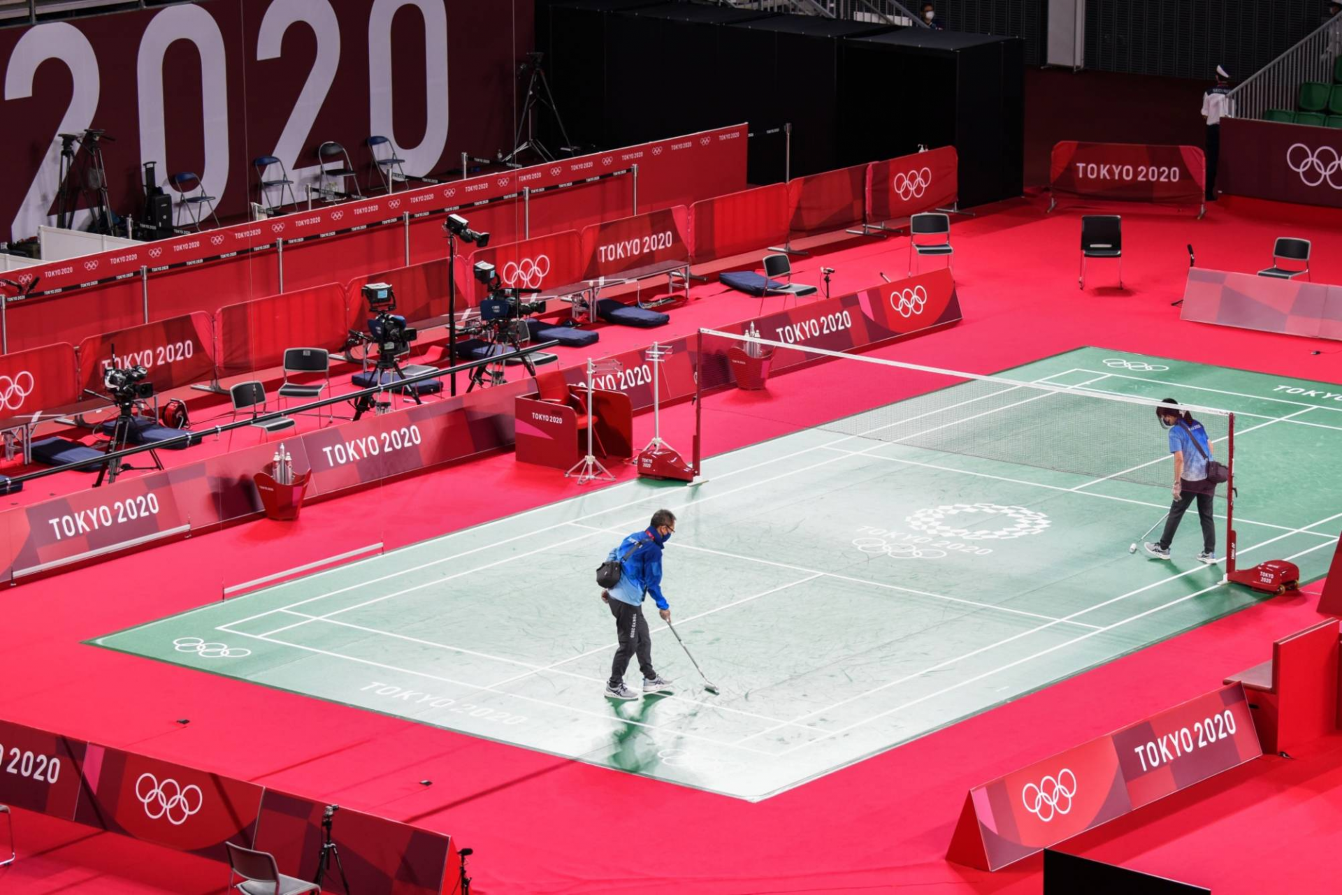 Volunteers clean up a court before badminton matches at the Musashino Forest Sport Plaza in Chofu, Tokyo. | BLOOMBERG Volunteers clean up a court before badminton matches at the Musashino Forest Sport Plaza in Chofu, Tokyo. | BLOOMBERG
