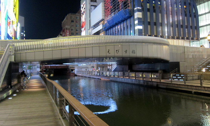 The pedestrian riverside area of Ebisu Bridge crossing Dotonbori River in Chuo Ward of Osaka City. Photo by Flickr/Wally Gobetz. The pedestrian riverside area of Ebisu Bridge crossing Dotonbori River in Chuo Ward of Osaka City. Photo by Flickr/Wally Gobetz.