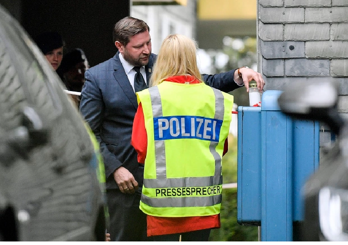Solingen's mayor Tim Kurzbach puts a candle at the entrance of the houseCredit: AP:Associated Press 0218 police