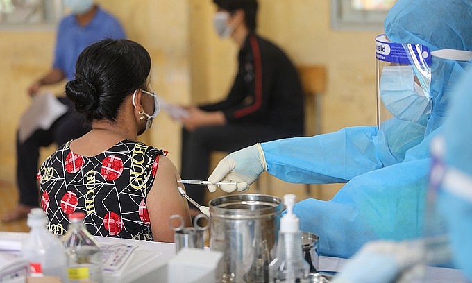 A woman receives a Covid-19 vaccine shot in HCMC's Thu Duc City, August 15, 2021. Photo: VnExpress A woman receives a Covid-19 vaccine shot in HCMC's Thu Duc City, August 15, 2021. Photo: VnExpress