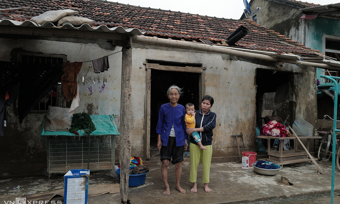 Le Thi Thuong stands with her daughter and grandchild in front of their damaged house in Quang Binh Province, central Vietnam, after floods receded, October 26, 2020. Photo by VnExpress/Ngoc Thanh. 3818 unfpa