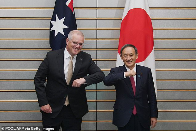 Scott Morrison and Yoshihide Suga bump elbows as they pose at the start of their bilateral meeting at Suga's official residence in Tokyo 4137 suga