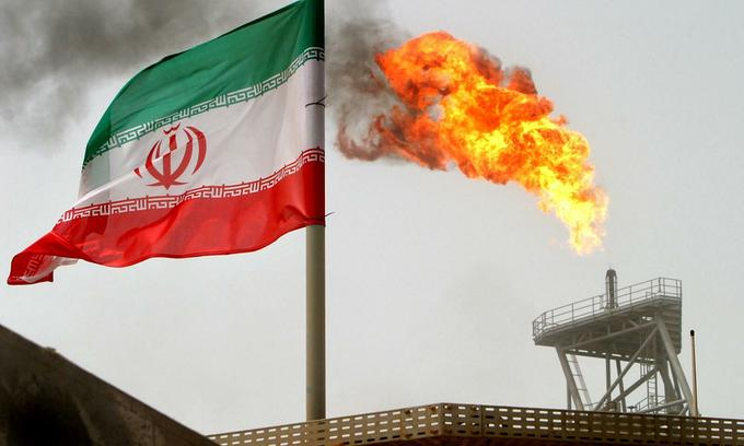 A gas flare on an oil production platform in the Soroush oil fields is seen alongside an Iranian flag in the Persian Gulf, Iran, July 25, 2005. Photo by Reuters/Raheb Homavandi. 1946 sanction