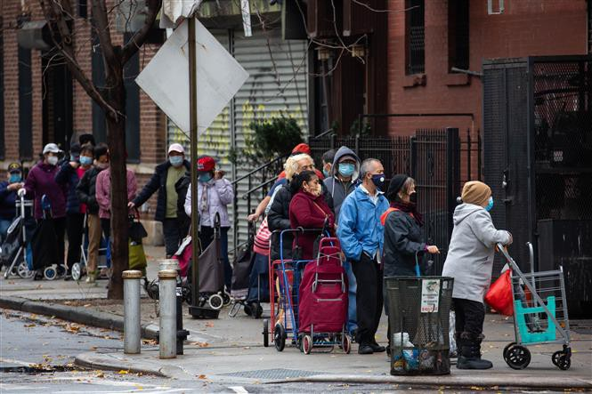 People wear masks while lining up in front of a grocery store in New York on November 12, 2020. (Photo: Xinhua/VNA) 1856 us