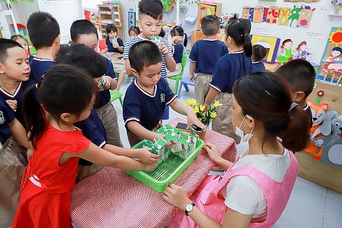Trong giờ uống sữa, các em tự giác gấp gọn vỏ hộp sữa và đặt đúng nơi quy định, góp phần hình thành ý thức bảo vệ môi trường. 5129 vnm236