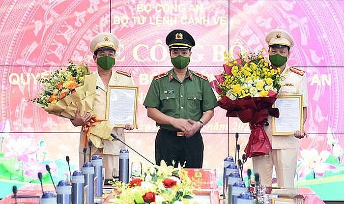 Thiếu tướng Trần Hải Quân (giữa) trao quyết định cho 2 cán bộ Thiếu tướng Trần Hải Quân (giữa) trao quyết định cho 2 cán bộ