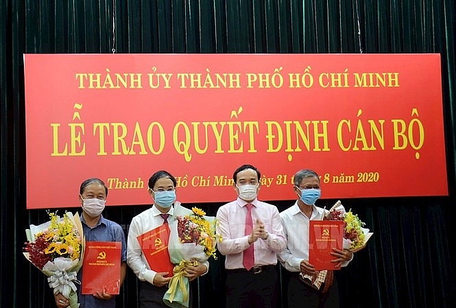 Ông Trần Lưu Quang (thứ 3 từ trái qua) trao quyết định cho các cán bộ vào sáng 31/8 (Ảnh: Thành ủy TP.HCM) 0601 nhieu lanh dao quan o tphcm nghi huu ong dao gia vuong duoc bo nhiem lam pho bi thu huyen uy binh chanh