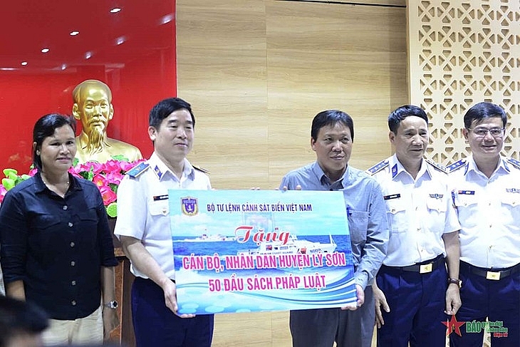 បញ្ជាការដ្ឋានប៉ូលីសសមុទ្រវៀតណាមប្រគល់សៀវភៅច្បាប់ជូនស្រុកកោះ Ly Son។ (រូបថត៖ qdnd.vn)