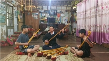 សិប្បកររក្សាអណ្ដាតភ្លើងក្លៀវក្លាជាមួយនឹងសូរសំឡេងនៃចាប៉ី ទីញតូវ (tinh tau) របស់ជនជាតិ​ Thai នៅខេត្ត Son La (វៀតណាម)