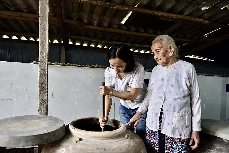 លោកយាយ Truong Thi Luan (អាយុ ៩១ឆ្នាំ) ណែនាំចៅប្រុសរបស់គាត់ពីរបៀបធ្វើទឹកត្រីតាមវិធីបុរាណ។ រូបថត៖ ង្វៀន ហុង លោកយាយ Truong Thi Luan (អាយុ ៩១ឆ្នាំ) ណែនាំចៅប្រុសរបស់គាត់ពីរបៀបធ្វើទឹកត្រីតាមវិធីបុរាណ។ រូបថត៖ ង្វៀន ហុង