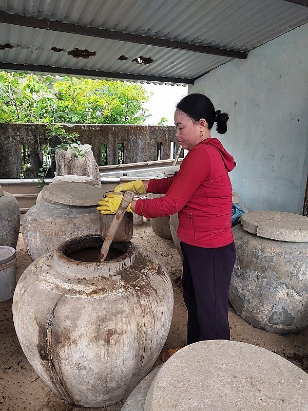លោកស្រី Nguyen Thi Hoi ពិនិត្យទឹកត្រីជប់របស់គ្រួសារគាត់។ លោកស្រី Nguyen Thi Hoi ពិនិត្យទឹកត្រីជប់របស់គ្រួសារគាត់។