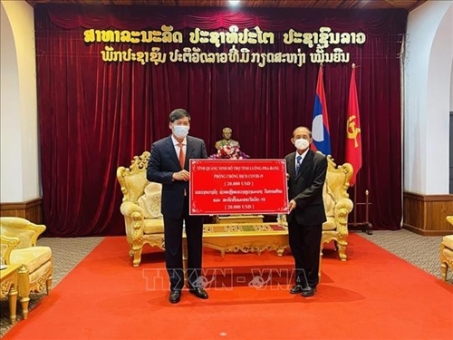 ທ່ານ ຫງວຽນດັງຮຸ່ງ ຫົວໜ້າສະຖານກົງສູນໃຫຍ່ຫວຽດນາມ ປະຈໍາ ຫຼວງພະບາງ ມອບຂອງຂວັນຂອງອົງຄະນະພັກ, ອໍານາດການປົກຄອງ ແລະປະຊາຊົນແຂວງກວ້າງນິງ ໃຫ້ແຂວງຫຼວງພະບາງ. ພາບ: ສໍານັກຂ່າວສານຫວຽດນາມ.