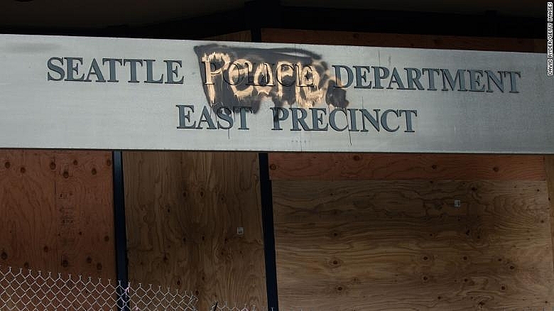 A defaced sign for the East Precinct reads Protests in America update: New York state approves to ban chokehold and others restrictions to cops