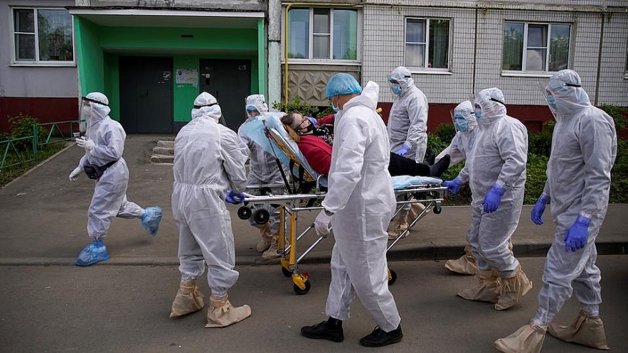 Paramedics and members of the Emergencies Ministry wearing personal protective equipment (PPE) use a stretcher while transporting a patient amid the coronavirus disease (COVID-19) outbreak in the city of Tver, Russia May 28. Photo: Reuters 0041 russia covid