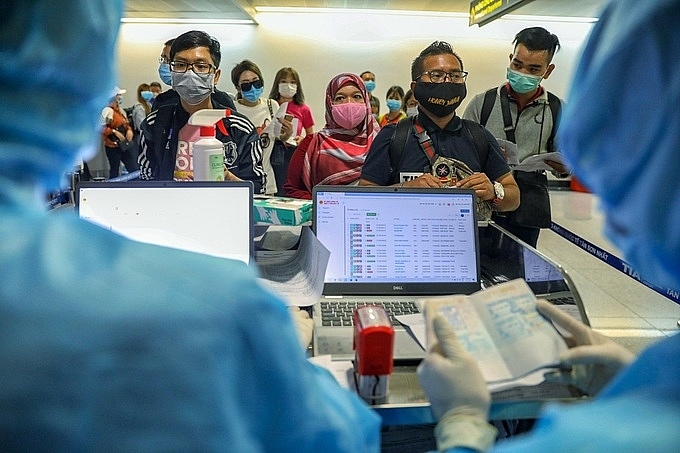 Foreigners carry out medical examinations at Tan Son Nhat airport before entering Vietnam on March 18. Photo: Huu Khoa. 2645 viet nam 3000