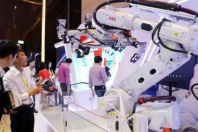 An engineer of the Switzerland company ABB controls a robot at the Industry 4.0 Summit Expo 2018 in Hanoi. Photo: VNS 2138 vn tech 2
