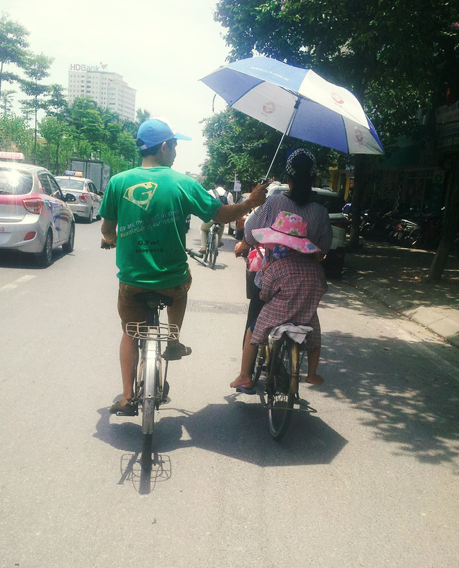 hinh anh de thuong ngay ha noi nong dinh diem nguoi dan ong chay xe dap che o cho hai me con tren pho
