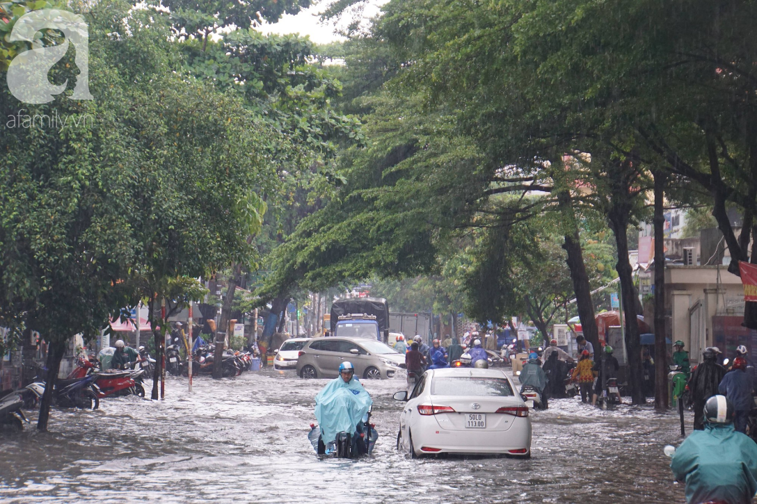 khu biet thu o sai gon ngap nang sau mua tre em truong quoc te duoc bo me cong tren vai loi nuoc ve nha