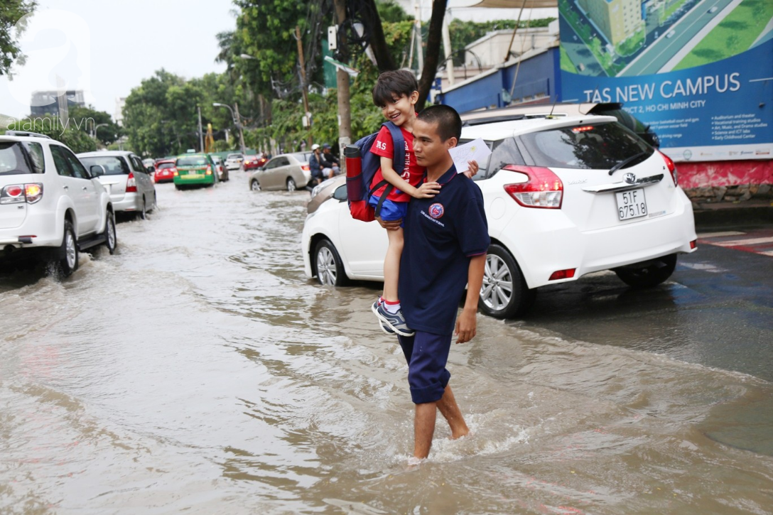 khu biet thu o sai gon ngap nang sau mua tre em truong quoc te duoc bo me cong tren vai loi nuoc ve nha